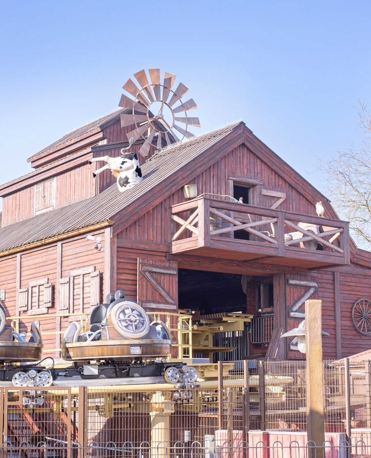 Image shows the bar building for the Storm Chaser rollercoaster at Tornado Springs in Paultons Park. There is a cow's bottom sticking out of the roof.