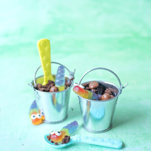 Image shows Buckets of Dirt 'n' Worms Dessert - two little galvanised steel buckets containing chocolate cake made to look like mud and gummy worms with little eyes in them. There are coloured plastic spoons for eating the desserts. Image by Sara-Jayne of Keep Up With The Jones Family.